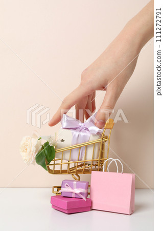 Shopping cart with flowers on a light background. 111272791