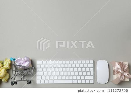 Keyboard and flowers with a shopping cart, on a light background. Keyboard and flowers with a shopping cart, on a light background. 111272796