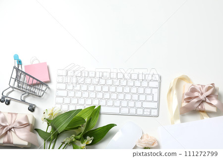 Keyboard and flowers with a shopping cart, on a light background. 111272799