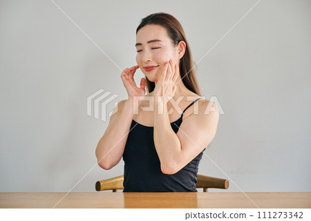 A woman in her 30s taking care of her skin by massaging her face A woman in her 30s taking care of her skin by massaging her face 111273342