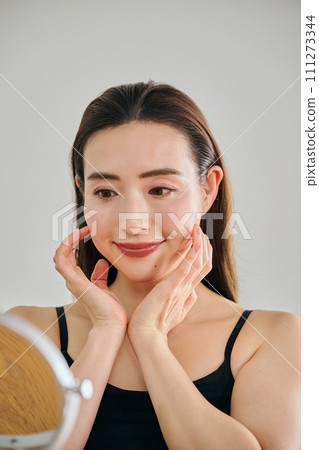 30多歲的女人透過按摩臉部來護理皮膚 30多歲的女人透過按摩臉部來護理皮膚 111273344