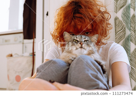 Portrait red-haired curly teenage girl with favorite fluffy domestic cat 111273474