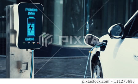 Electric car connected to charging station at city center. Peruse 111273693