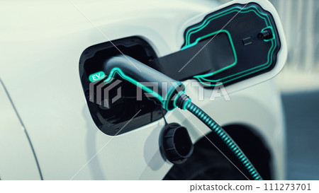 Electric car plugged in with home charging station. Peruse 111273701