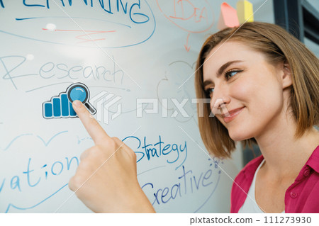 Businesswoman puts sticker on glass board while finding a solution. Immaculate. 111273930