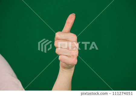 Closeup of female hand showing thumbs up sign against body parts of a young woman on a green background chromakey Closeup of female hand showing thumbs up sign against body parts of a young woman on a green background chromakey 111274051