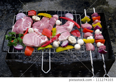 fresh raw beef shish kebab with pepper chunk on black big grill bbq Raw meat skewers with vegetables on wooden background 111274103
