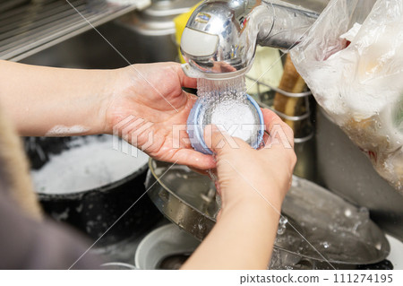 A woman washing a water bottle by hand 111274195