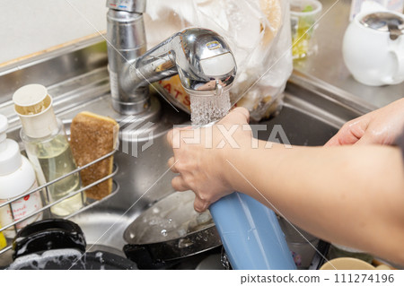 A woman washing a water bottle by hand A woman washing a water bottle by hand 111274196