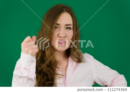 Young woman in black top punching the air in victory and success. Air punch. UK 111274369