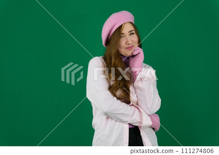 Lovely girl wearing pink french hat. young girl woman with a pink beret on her head France fashion on a green background chromakey. different emotions pink jacket gloves long brown hair. pink winter 111274806