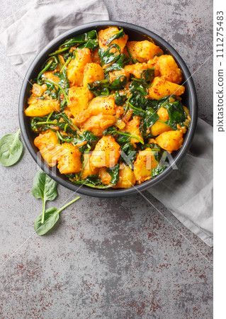 Aloo Palak sabzi Spinach Potatoes curry served in a bowl closeup. Vertical top view 111275483