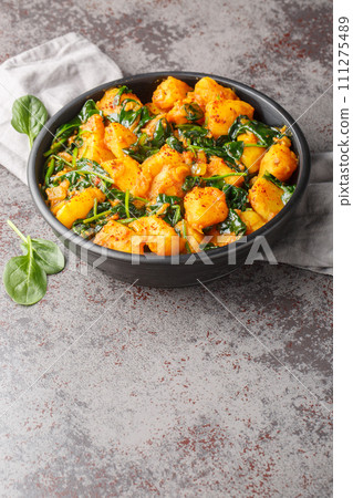 Aloo Palak sabzi Spinach Potatoes curry served in a bowl closeup. Vertical 111275489