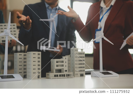Close-up at tablet, Engineers pointing at tablet with their hands. To jointly design the use of renewable energy with wind and solar energy. Concept of using renewable energy. 111275932