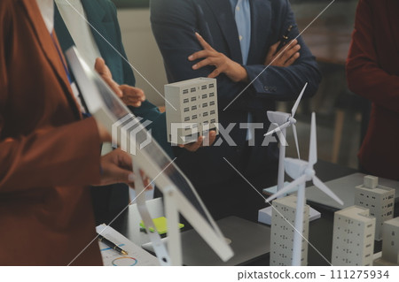 Close-up at tablet, Engineers pointing at tablet with their hands. To jointly design the use of renewable energy with wind and solar energy. Concept of using renewable energy. Close-up at tablet, Engineers pointing at tablet with their hands. To jointly design the use of renewable energy with wind and solar energy. Concept of using renewable energy. 111275934