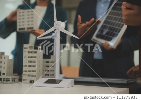 Close-up at tablet, Engineers pointing at tablet with their hands. To jointly design the use of renewable energy with wind and solar energy. Concept of using renewable energy. Close-up at tablet, Engineers pointing at tablet with their hands. To jointly design the use of renewable energy with wind and solar energy. Concept of using renewable energy. 111275935