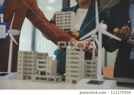 Close-up at tablet, Engineers pointing at tablet with their hands. To jointly design the use of renewable energy with wind and solar energy. Concept of using renewable energy. Close-up at tablet, Engineers pointing at tablet with their hands. To jointly design the use of renewable energy with wind and solar energy. Concept of using renewable energy. 111275936