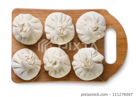 Khinkali on a wooden board close-up on a white. Top view Khinkali on a wooden board close-up on a white. Top view 111276087