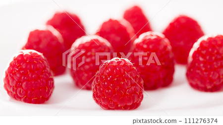 Handful of raspberry berries on white background 111276374