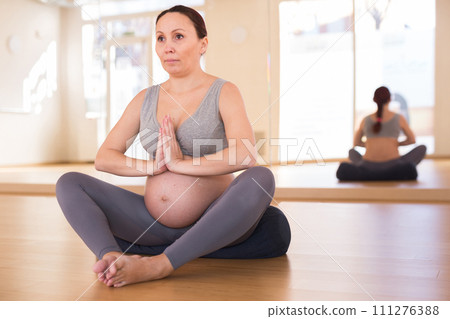 Pregnant woman is engaged in yoga. Butterfly Pose or Baddha Konasana Pregnant woman is engaged in yoga. Butterfly Pose or Baddha Konasana 111276388