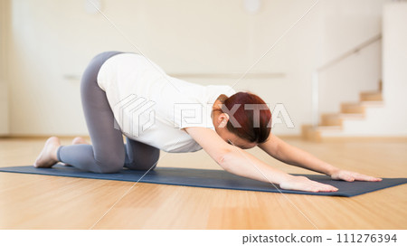 Pregnant woman is engaged in yoga. Baby asana or Balasana Pregnant woman is engaged in yoga. Baby asana or Balasana 111276394