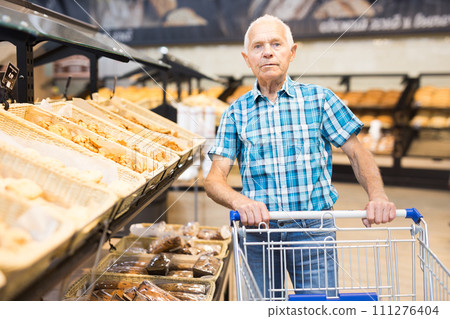 Old age senor examines bakery products in the grocery section of the supermarket Old age senor examines bakery products in the grocery section of the supermarket 111276404