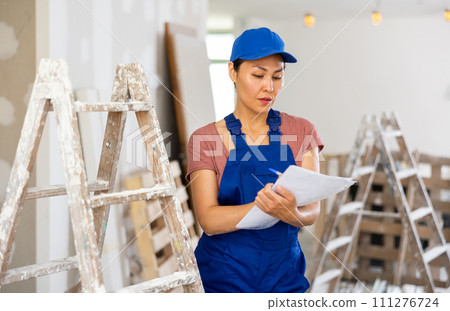Female engineer matching check list during repair works Female engineer matching check list during repair works 111276724
