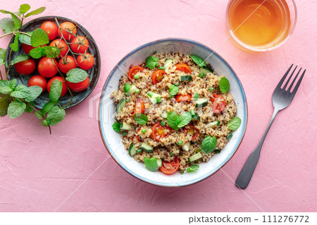 Quinoa tabbouleh salad in a bowl, a healthy dinner with tomatoes and mint Quinoa tabbouleh salad in a bowl, a healthy dinner with tomatoes and mint 111276772