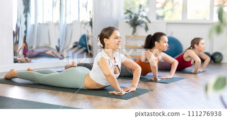 Young woman performing Urdhva Mukha Shvanasana at group yoga class Young woman performing Urdhva Mukha Shvanasana at group yoga class 111276938