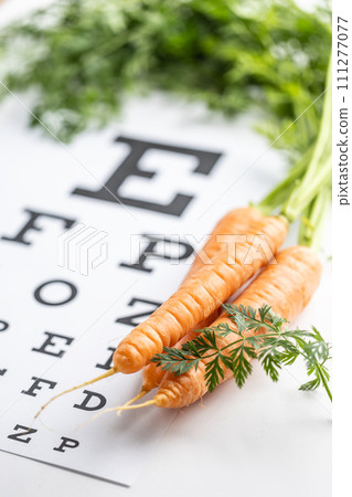 Fresh carrots as a source of vitamin A placed on the eye test chart Fresh carrots as a source of vitamin A placed on the eye test chart 111277077