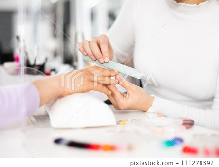 Woman hands, with which the manicure master files nails 111278392