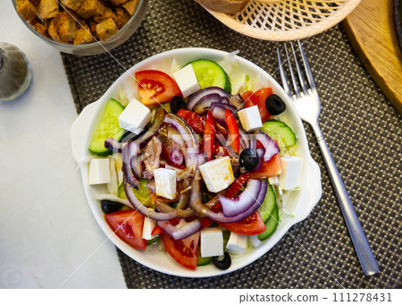 Plate of tasty Greek salad with fresh cucumbers, bell pepper and feta cheese Plate of tasty Greek salad with fresh cucumbers, bell pepper and feta cheese 111278431