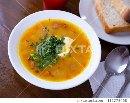 Plate of pea soup with smoked meats. 111278468