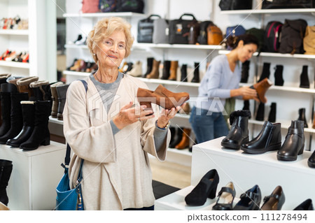 Senior woman shopping in shoeshop Senior woman shopping in shoeshop 111278494