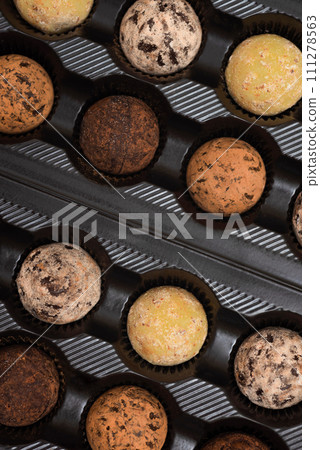 Chocolates in a box on a black background. Top view. Chocolates in a box on a black background. Top view. 111278563
