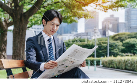 讀一張報紙的商人在公園 讀一張報紙的商人在公園 111278842