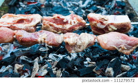 preparation of a shish kebab from pork meat on coals preparation of a shish kebab from pork meat on coals 111279572