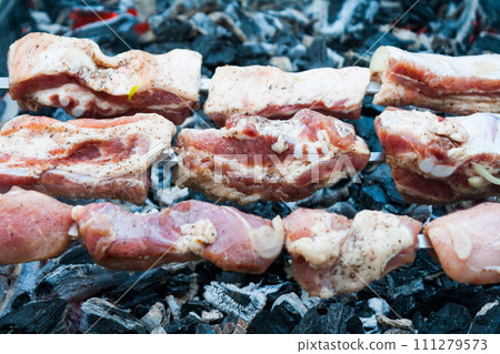 preparation of a shish kebab from pork meat on coals preparation of a shish kebab from pork meat on coals 111279573