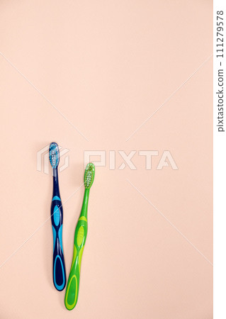 Two toothbrushes on a beige background, top view, space for text. 111279578