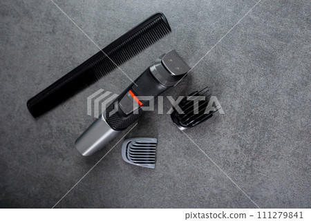 Wireless hair trimmer and beard on gray stone background 111279841