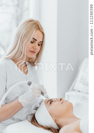 A woman enjoys a luxurious SPA complex in a beauty salon with a beautician, which includes a variety of facial and body treatments to achieve complete beauty and relaxation. 111280399