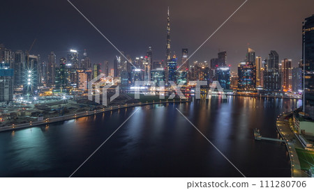 Aerial view to Dubai Business Bay and Downtown with the various skyscrapers and towers all night timelapse 111280706