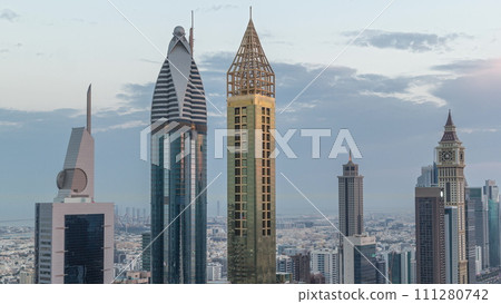 Skyline view of the high-rise buildings on Sheikh Zayed Road in Dubai aerial night to day timelapse, UAE. 111280742