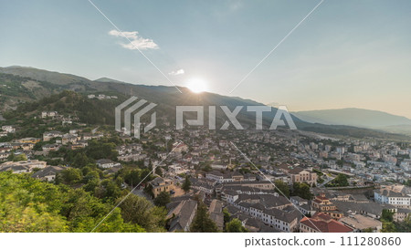 Panorama showing sunset over Gjirokastra city from the viewpoint of the fortress of the Ottoman castle of Gjirokaster timelapse. 111280860