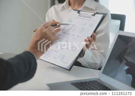 Close up view of job interview in office, focus on resume writing tips, employer reviewing good cv of prepared skilled applicant, recruiter considering application, hr manager making hiring decision Close up view of job interview in office, focus on resume writing tips, employer reviewing good cv of prepared skilled applicant, recruiter considering application, hr manager making hiring decision 111281272