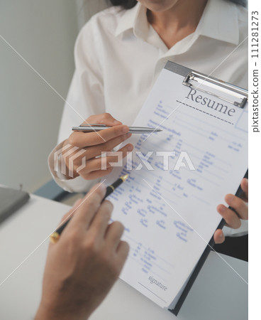 Close up view of job interview in office, focus on resume writing tips, employer reviewing good cv of prepared skilled applicant, recruiter considering application, hr manager making hiring decision Close up view of job interview in office, focus on resume writing tips, employer reviewing good cv of prepared skilled applicant, recruiter considering application, hr manager making hiring decision 111281273