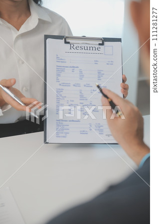Close up view of job interview in office, focus on resume writing tips, employer reviewing good cv of prepared skilled applicant, recruiter considering application, hr manager making hiring decision Close up view of job interview in office, focus on resume writing tips, employer reviewing good cv of prepared skilled applicant, recruiter considering application, hr manager making hiring decision 111281277