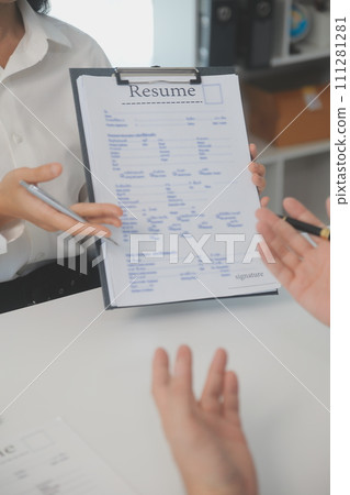 Close up view of job interview in office, focus on resume writing tips, employer reviewing good cv of prepared skilled applicant, recruiter considering application, hr manager making hiring decision 111281281