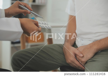 Male diseases. Man presses hands to his groin and suffering from pain, panorama, cropped, studio shot Male diseases. Man presses hands to his groin and suffering from pain, panorama, cropped, studio shot 111281416