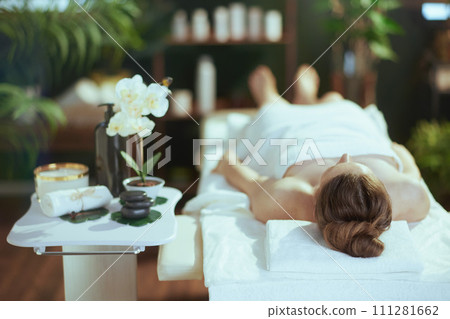 relaxed modern woman in massage cabinet laying on massage table relaxed modern woman in massage cabinet laying on massage table 111281662